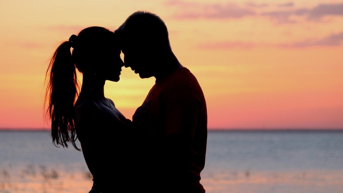 Romantic Couple Silhouetted Against Sunset