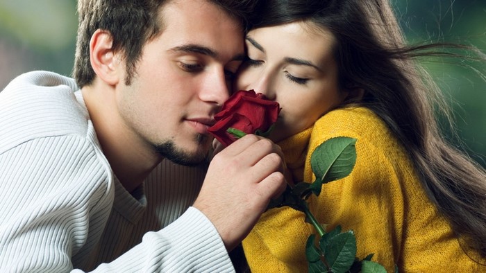 Couple smelling a red rose