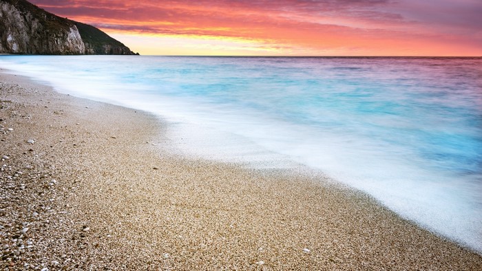 Ocean beach at sunset with cliffs