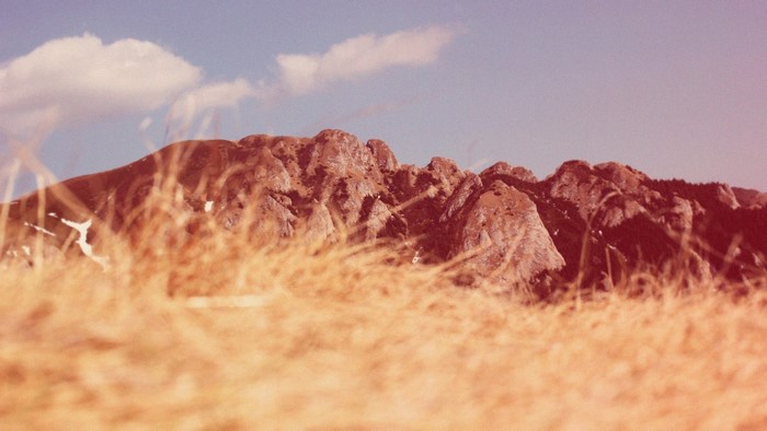 Mountain crest with yellow grass and clouds