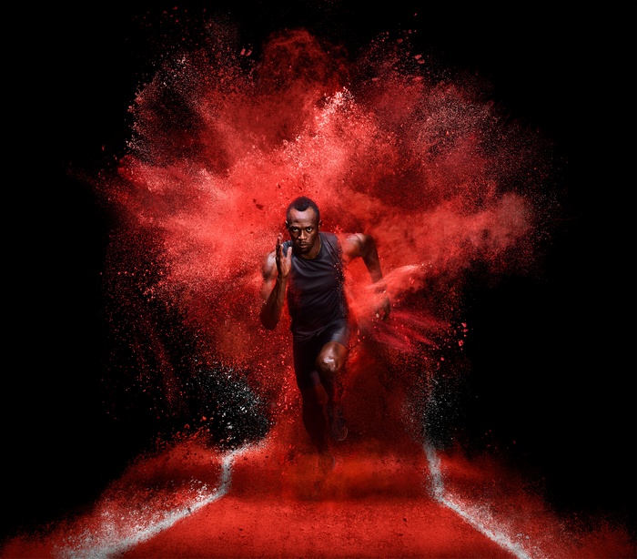 Usain Bolt running through red powder explosion