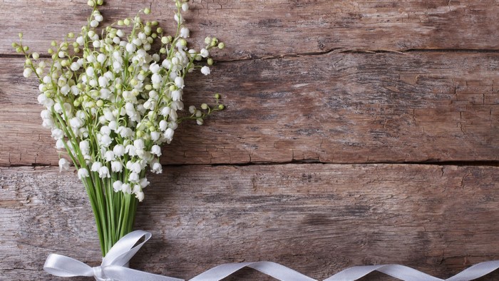 Lily of the valley bouquet on wooden background