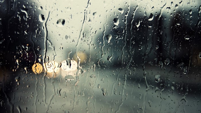Raindrops on a window with blurred lights