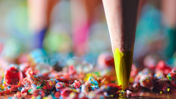 Close-up of a yellow pencil tip with colorful shavings