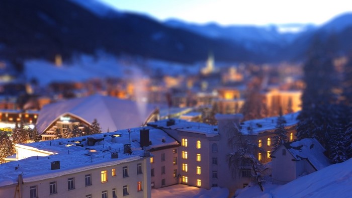 Snowy buildings in a mountain town at dusk