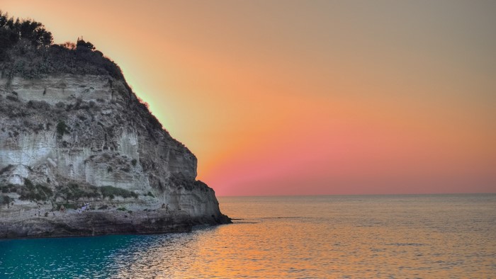 Cliff overlooking ocean at sunset