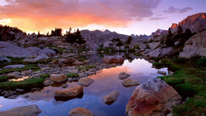 Mountain lake at sunset with rocky shore