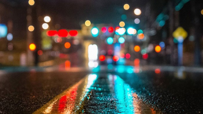 Rainy city road at night with bokeh lights