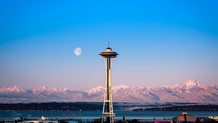 Space Needle and Moon over Snowy Mountains