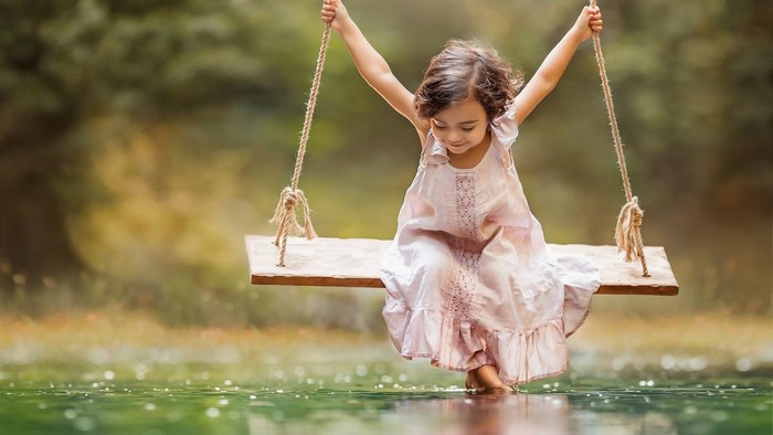 Girl on a swing over water