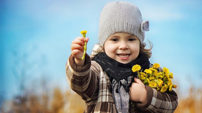 Young girl holding yellow flowers