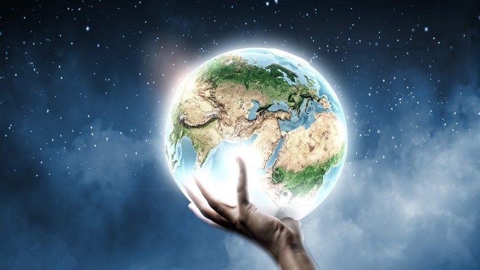 Earth Globe Held in Hand Against Starry Sky