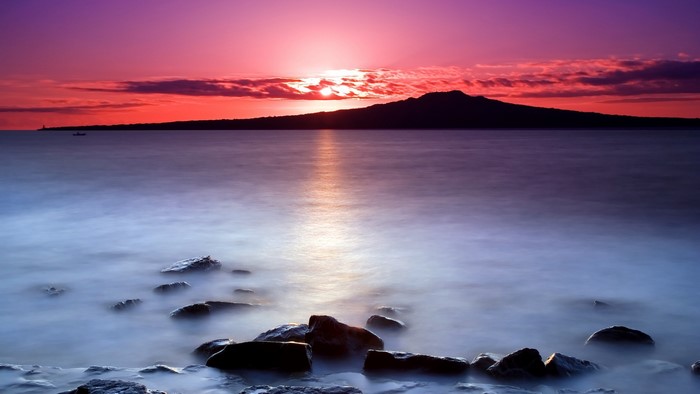 Sunset over a calm lake with rocks
