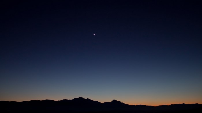 Crescent Moon Over Mountain Silhouette at Dusk