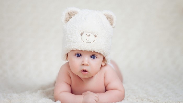 Baby wearing a teddy bear hat