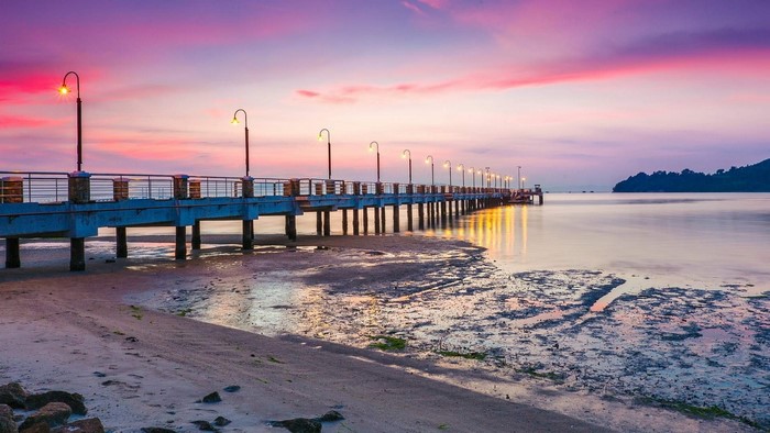 Long bridge over the sea at sunset