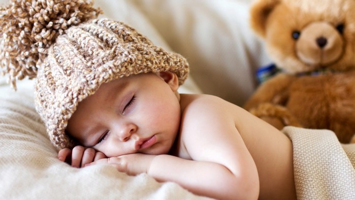 Newborn baby sleeping with teddy bear