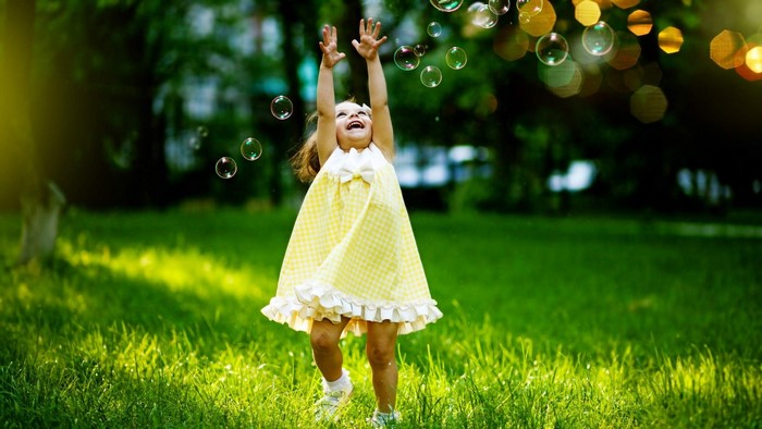 Happy Girl Playing with Bubbles in a Park