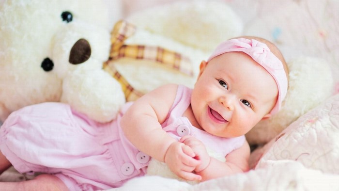 Baby smiling with teddy bear