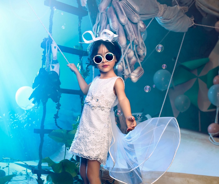 Cute girl in a white costume with sunglasses