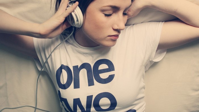 Girl wearing headphones and a t-shirt with text
