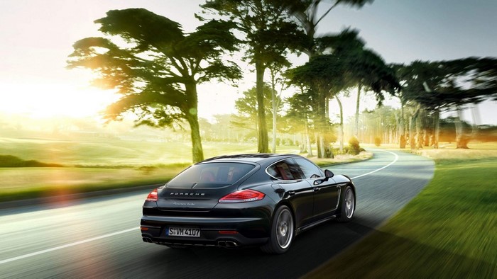 Black Porsche Panamera driving on a scenic road