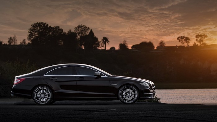 Black Mercedes-Benz CLS63 AMG by a lake at sunset