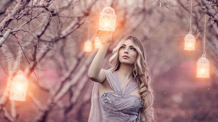 Girl holding a magic lantern in a forest