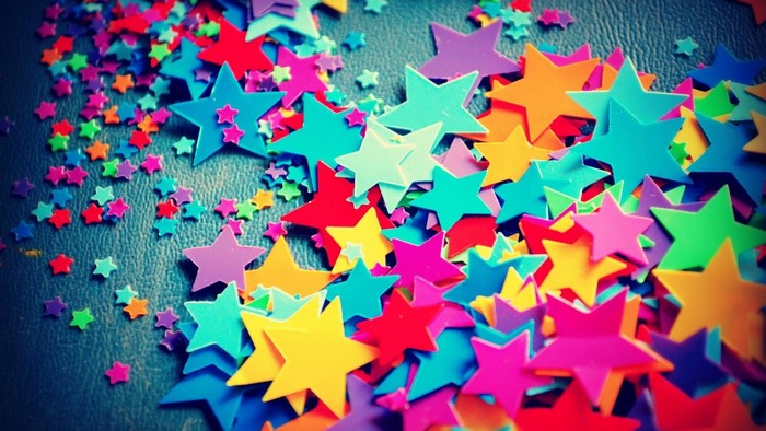 Colorful Star Confetti Scattered on a Dark Surface