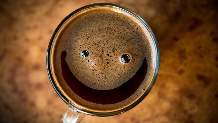 Coffee cup with a smiley face made of foam