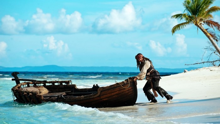 Jack Sparrow pushing a boat on a beach