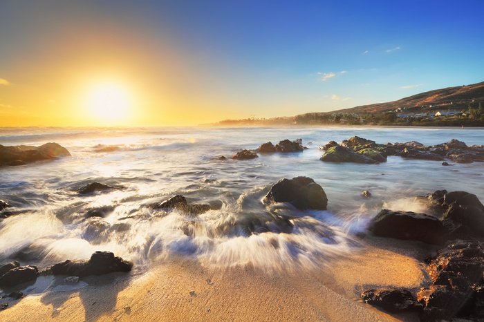 Sunrise over a rocky beach with waves