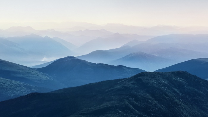 Layered blue mountains under a pale sky