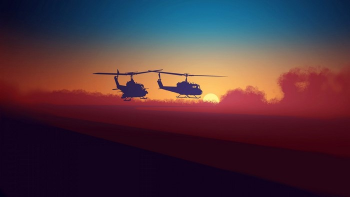 Two helicopters flying at sunset