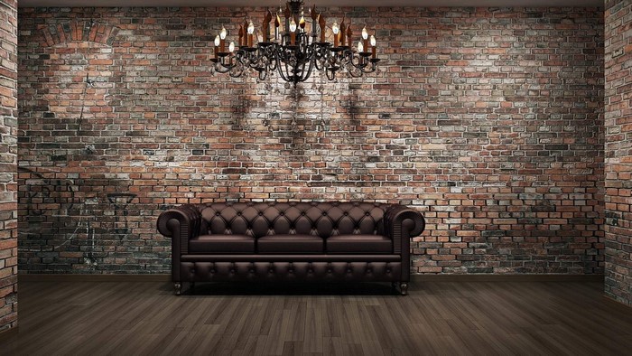 Leather sofa in front of a brick wall with a chandelier