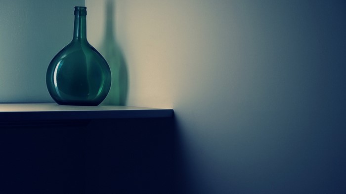 Green glass bottle on a shelf