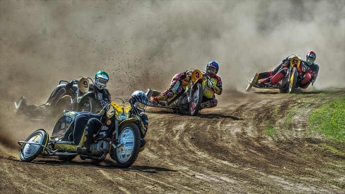 Sidecar motorcycles racing on a dirt track