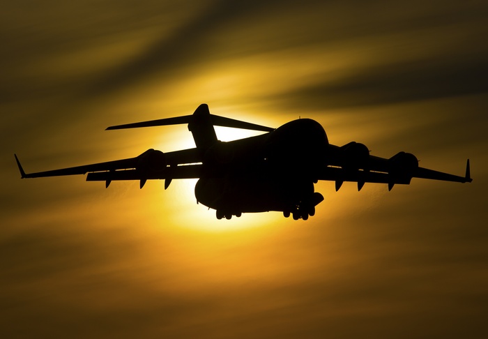 Silhouette of a Boeing C-17 Globemaster III aircraft against the sun