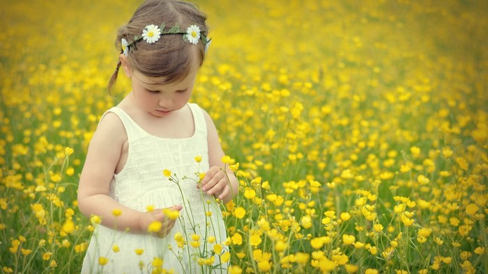 Cute girl in a field of yellow flowers