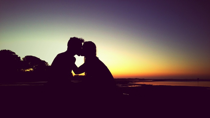 Couple kissing at sunset silhouette