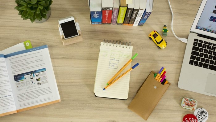 Desk with laptop, books, phone, and stationery