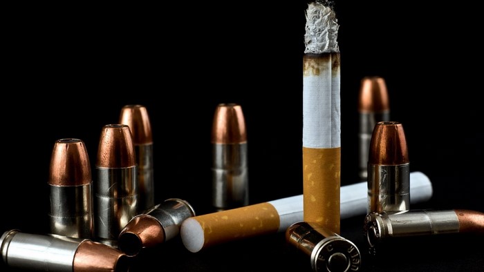 Bullets and a lit cigarette on a black background