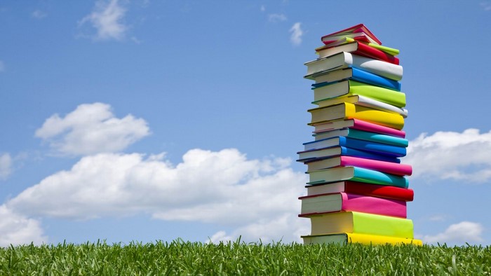 Stack of colorful books against blue sky