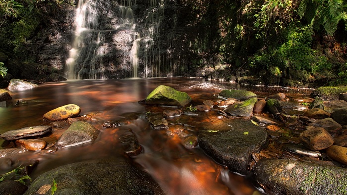 Waterfall flowing over rocks into a stream
