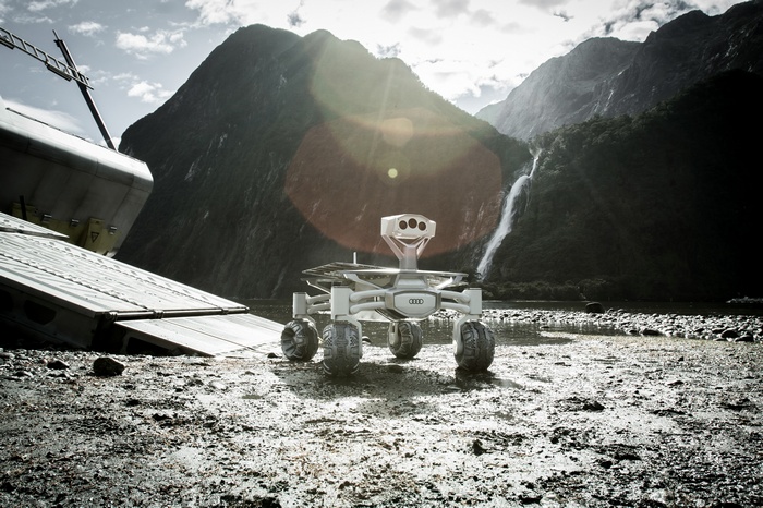Audi Lunar Quattro Rover on a rocky shore with waterfall