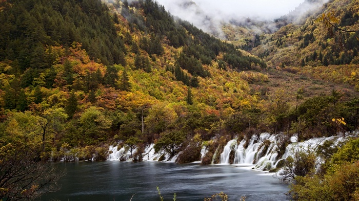 Autumn forest with waterfalls and a lake