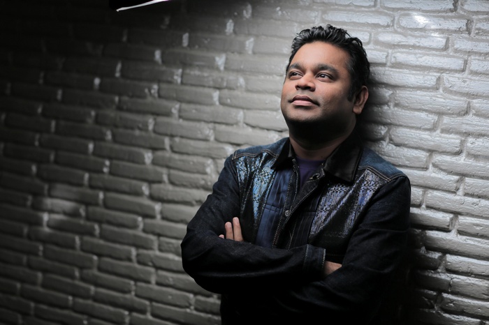 AR Rahman leaning against a brick wall