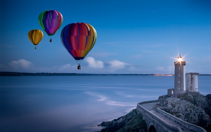 Hot air balloons over the sea near a lighthouse