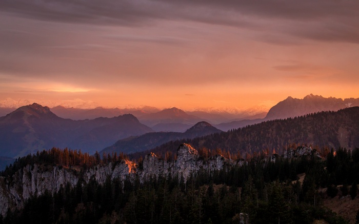 Sunset over mountain ranges with pine forest