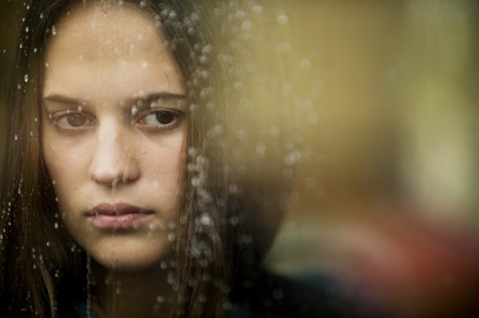 Alicia Vikander through a rainy window